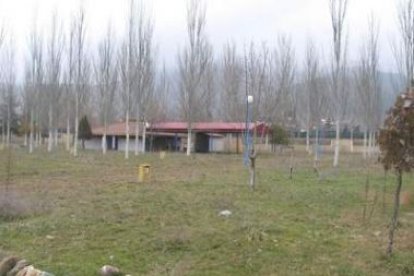 Instalaciones del cámping de Cistierna con el edificio de servicios y duchas, al fondo.