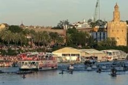 Los seguidores vitorean al Sevilla a la orilla del Guadalquivir y en barcos