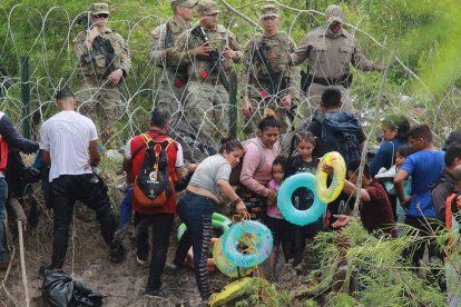 Los padres dan a los niños flotadores para cruzar el río. ABRAHAM PINEDA JACOME