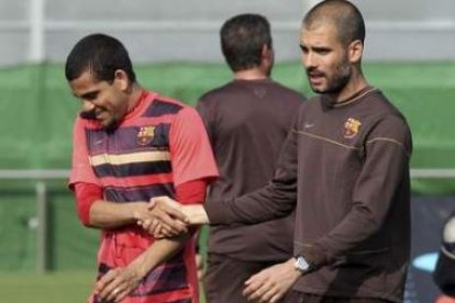 Pep Guardiola, a la derecha, bromea con el brasileño Dani Alves durante el entrenamiento realizado a