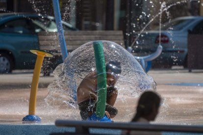 Varios niños se refrescan en una plaza de la ciudad cántabra de Torrelavega el 23 de agosto. PEDRO PUENTE HOYOS