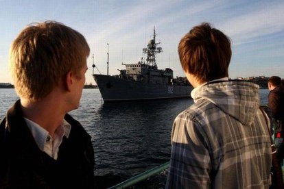 Dos personas observan la nave rusa 'Turbinist' en la bahía de Sebastopol (Crimea), este miércoles.