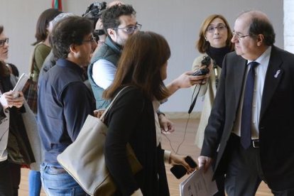 El presidente de la Junta de Castilla y León, Juan Vicente Herrera (d), es perseguido por un grupo de periodistas por los pasillos de las Cortes de Castilla y León.
