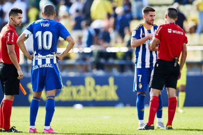 Yuri y Dani Ojeda esperan junto a los árbitros la decisión sobre el tanto de Naranjo que el VAR acabó dando como no válido de forma incomprensible. SERGIO POZO