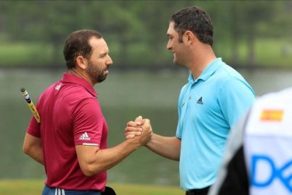 Jon Rham choca la mano con Sergio García después de cerrar su pase a octavos