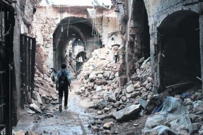 Un miliciano camina por entre las ruinas que han dejado los bombardeos en el zoco antiguo de Alepo, una ciudad habitada desde hace 7.000 años.