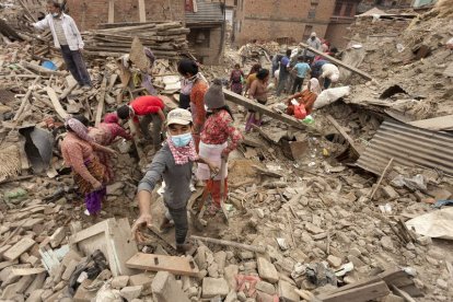 Varias personas buscan sus pertenencias en las ruinas de un edificio en Bhaktapur.