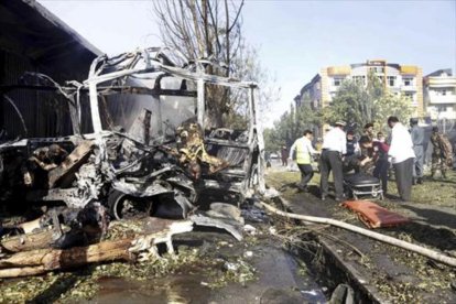 Rescate de víctimas entre los restos calcinados del autobús atacado en Kabul