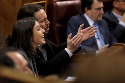 Irene Montero y Pablo Iglesias gesticulan durante la intervención de Soraya Sáenz de Santamaría en la sesión de control.