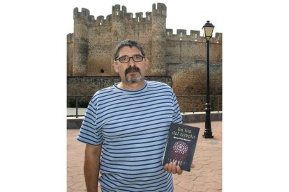 Mendoza sostiene su libro ante el castillo de Coyanza.