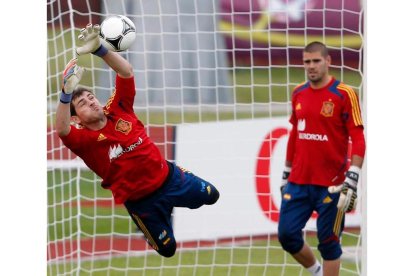 Casillas detiene un balón junto a Víctor Valdés durante el entrenamiento del equipo en Gniewino.