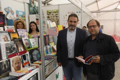 En la imagen de la izquierda, el concejal de Cultura y el alcalde de La Bañeza ayer en la Feria del Libro; en la derecha el stand del Diario de León. FERNANDO OTERO