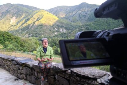 Eva González, vecina de Palacios del Sil, durante una de las grabaciones. Al fondo, los picos Cerisaléu y Solumbreiru. RICI COMUNICACIÓN