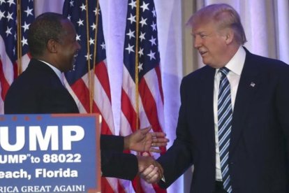 Trump (derecha) estrecha la mano del excandidato Ben Carson, en Palm Beach (Florida), este viernes.