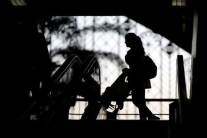 Una madre y su hijo, en una estación de tren.