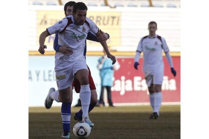 Murci encara la portería del Tordesillas obstaculizado por un jugador vallisoletano.