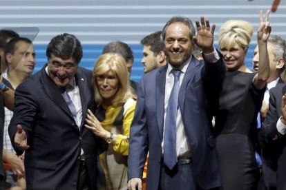 Daniel Scioli, segundo por la derecha, saluda junto a su esposa Karina Rabolini y a su candidato a vicepresidente Carlos Zannini en el acto de cierre de campaña en Buenos Aires.