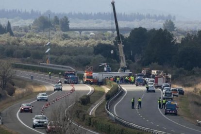 Las grúas retiran el autocar siniestrado, ayer en Freginals.