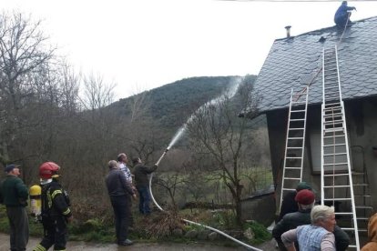 Vecinos y bomberos intentando sofocar el fuego.