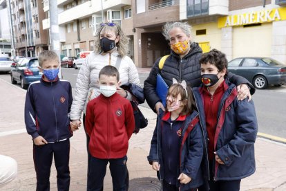 Fátima González, con Germán y Marcos, y Olga Rejas, con Sara y Guillermo, ayer a la salida del colegio, en La Chantría. M. PÉREZ