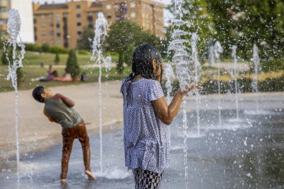 Unos niños se refrescan bajo una fuente en Logroño. RAQUEL MANZANARES