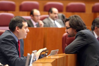 El procurador popular Alfonso García Vicente (D) conversa con el socialista Miguel Ángel Fernández Cardo en el Pleno de las Cortes