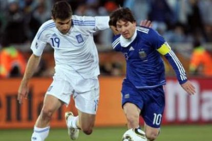 El argentino Messi y el griego Sokrat pugnan por un balón.