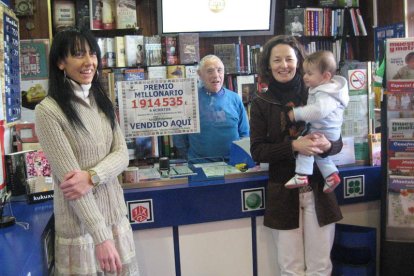 Las hermanas Aranchi y Susana posan en su librería, delante de su padre, Olegario.