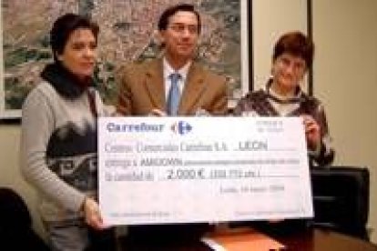 El director de Carrefour en León, Antonio Márquez , hace entrega del cheque a Amidown