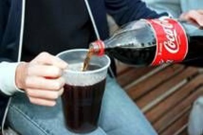 Un joven mezcla una bebida alcohólica con cola para «hacer botellón»