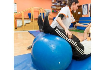 Un enfermo de ELA en el gimnasio de la Asociación de Esclerosis Múltiple de León. FERNANDO OTERO