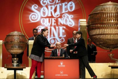 Daniela Laborde Valverde (i) canta los números junto a su compañero Francisco Moreno Durán (d), que canta los premios, durante el sorteo de El Gordo de Navidad en el Teatro Real en Madrid. JAVIER LIZÓN