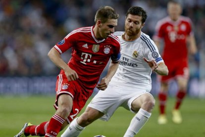 Xabi Alonso, a la derecha, disputa un balón con el defensa del Bayern de Múnich Philipp Lahm durante un lance del partido.