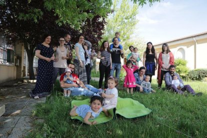 Padres y madres de la asociación 'Creciendo Juntos' posan con sus hijos en un jardín de Puente Castro.