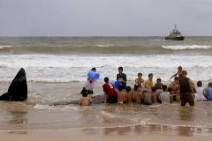 Un niño se zambulle en el agua mientras juega con sus amigos