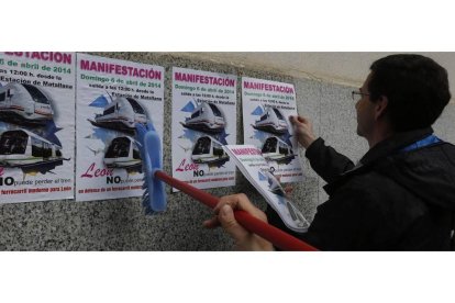 Pegada de carteles en la Estación de Feve en león convocando a la manifestación del domingo