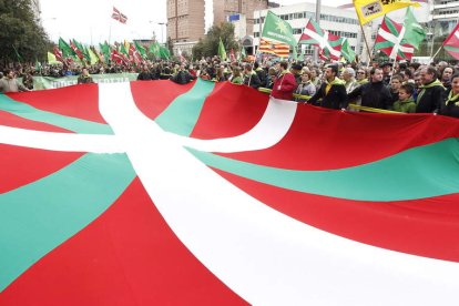 Una ikurriña preside la multidunaria manifestación exigiendo la independencia de Euskadi.