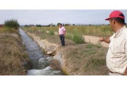 El guardia del agua señala uno de los múltiples lugares donde la acequia del canal está fracturada.