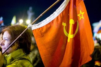 Una mujer sostiene una bandera soviética en la plaza de Lenin, en Simferopol, este domingo.