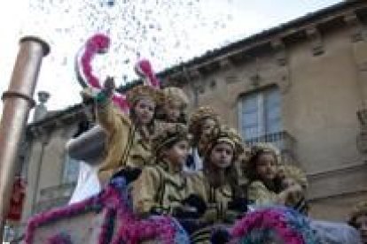 Una niña arroja confetis desde una de las carrozas que formaban el desfile infantil de este año