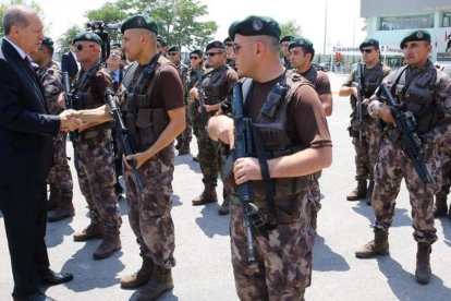 Erdogan (izquierda) saluda a un agente durante su visita al cuartel general del departamento policial de operaciones especiales, en Ankara, el 29 de julio.