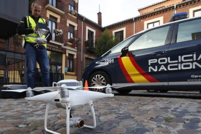 Los policías nacionales acompañan, ayer, al operador de drones para comprobar que todo está en regla. RAMIRO