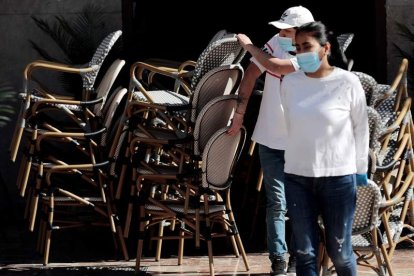 Dos camareros colocan una terraza en Valencia. ANA ESCOBAR