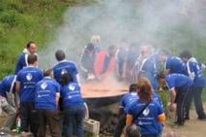 Miembros de club de lucha leonesa elaborando la paella popular