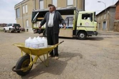 Uno de los afectados por el problema del arsénico lleva varias garrafas de agua