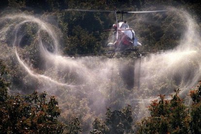 Un aspersor riega con pesticidas un campo de cultivo.