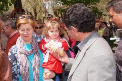 Una niña, con el bollo de pan, espera el reparto del queso.