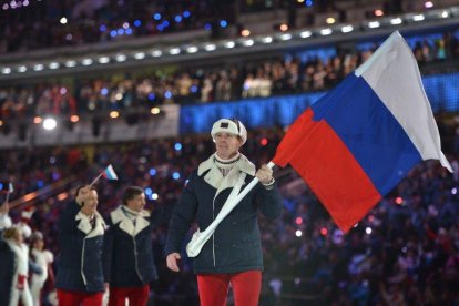 Alexandr Zubkov, con la bandera rusa en el desfile de Sochi, es uno de los deportistas sancionados por dopaje.