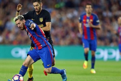 Messi disputa un balón con Carrasco en el Camp Nou antes de lesionarse.