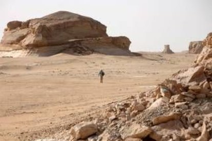 Imagen de archivo de un turista caminando en un desierto de Egipto